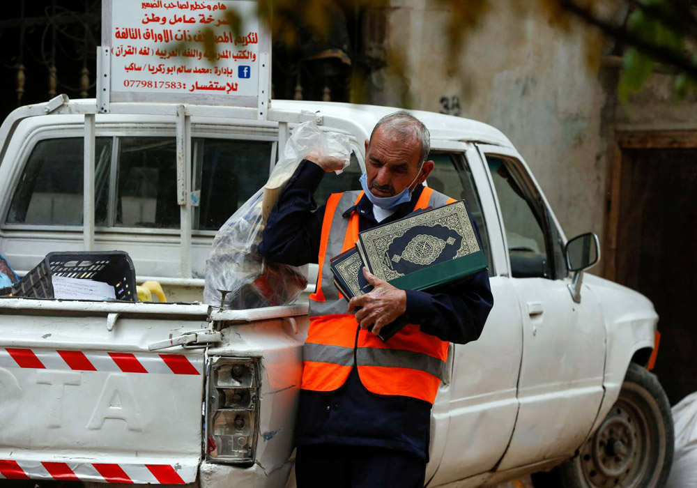 محمد سالم أبوزكريا يحاول جمع ما أمكن من الكتب الملقاة في الشوارع خاصة الكتب المدرسية