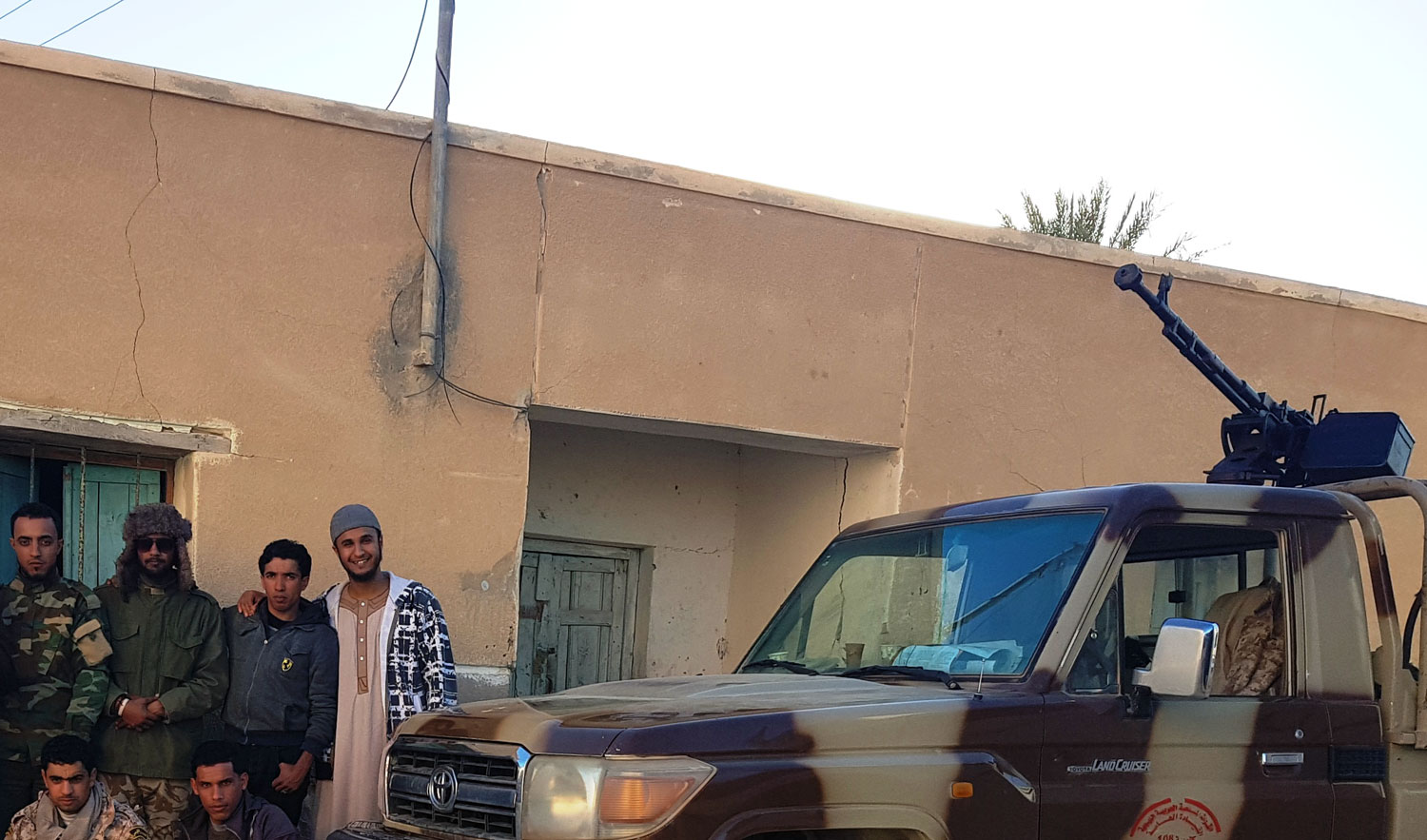 صورة تذكارية لجنود من الجيش الليبي في تجمع سكاني في الصحراء الليبية
